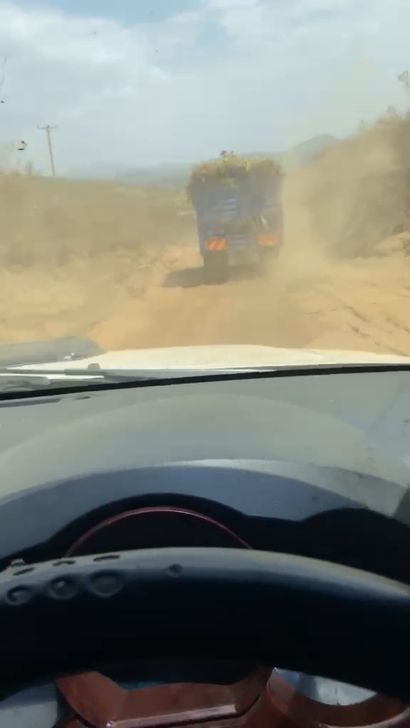 A truck ahead on a dusty rural road in the Rift Valley.